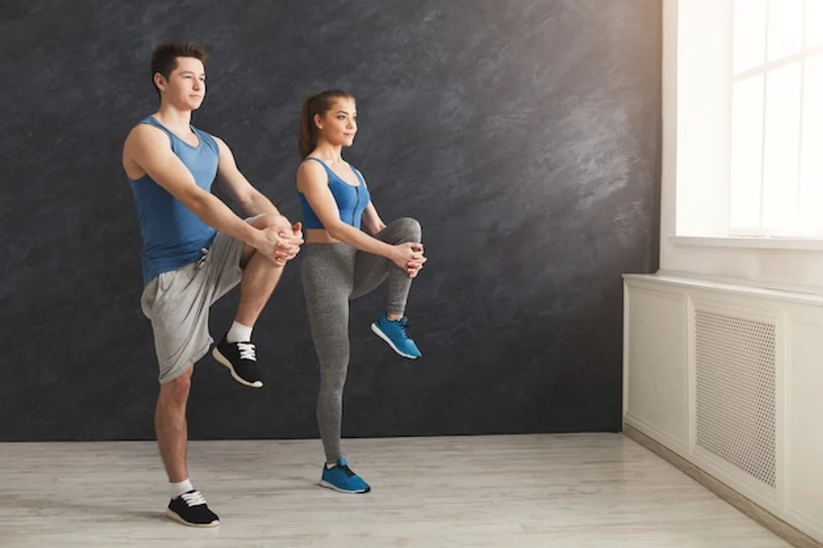 dynamic stretching in the gym with man and woman warming up