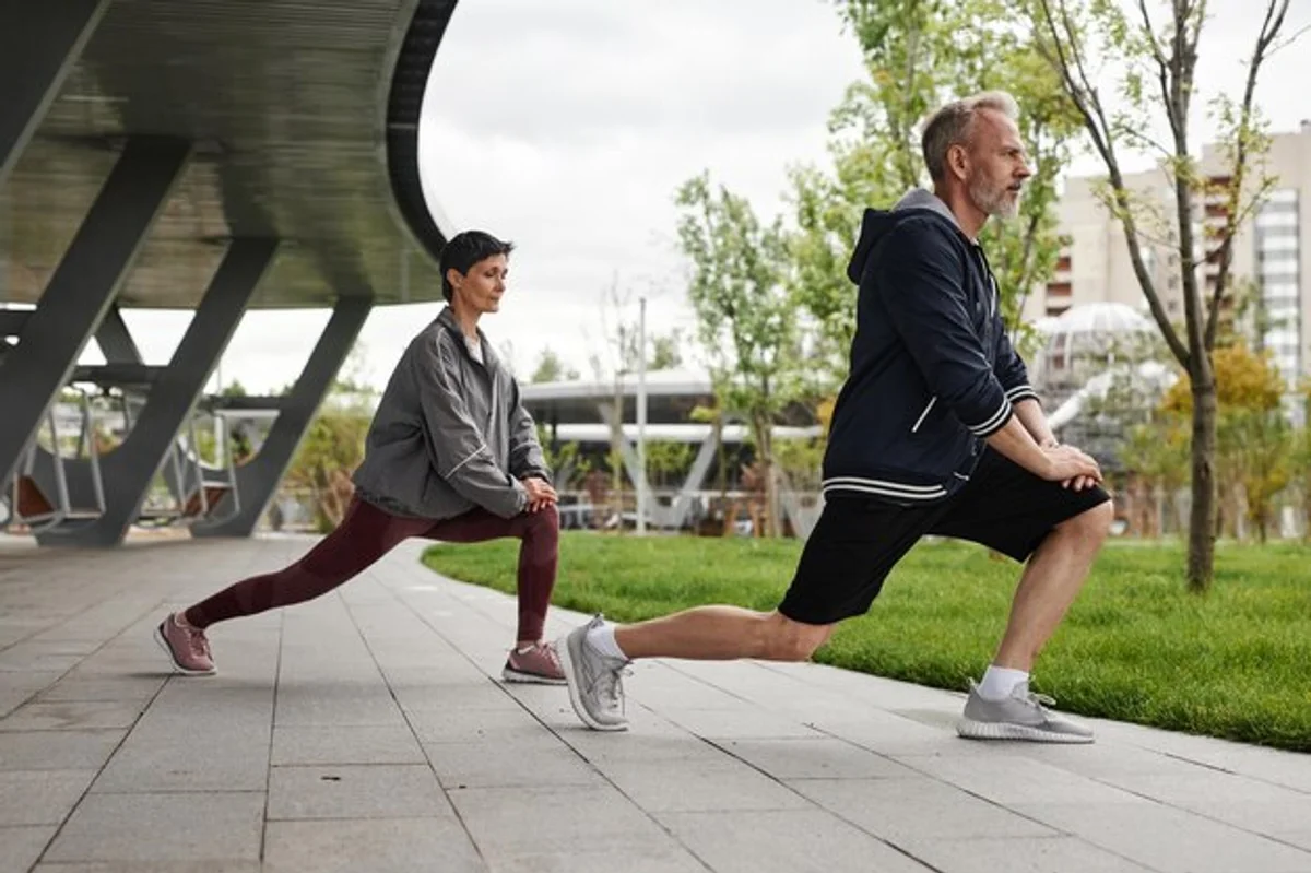 static stretching after workout in park mature woman healthy lifestyle