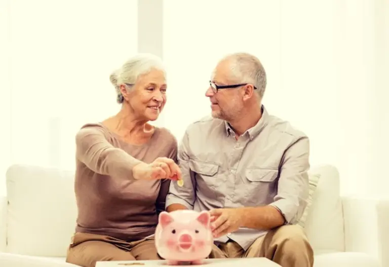 happy senior couple saving money at home