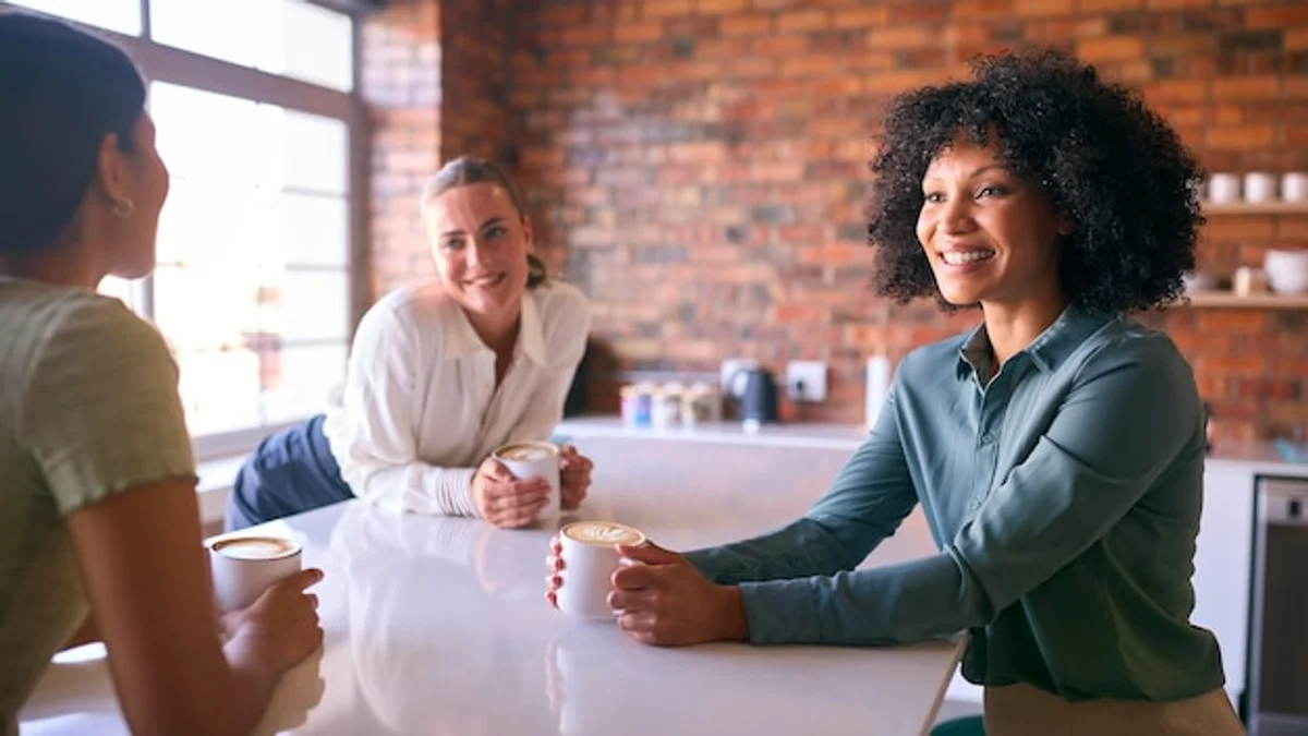 people taking a creative break in a modern office, relaxing with coffee and smiling