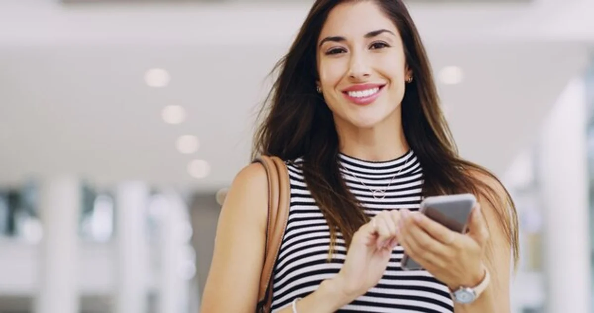 happy woman saving money at supermarket using smartphone app