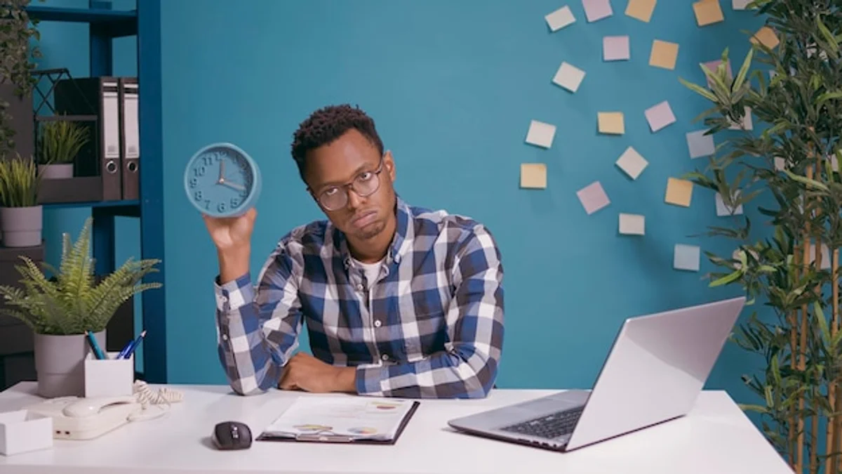 tired office worker looking at timer