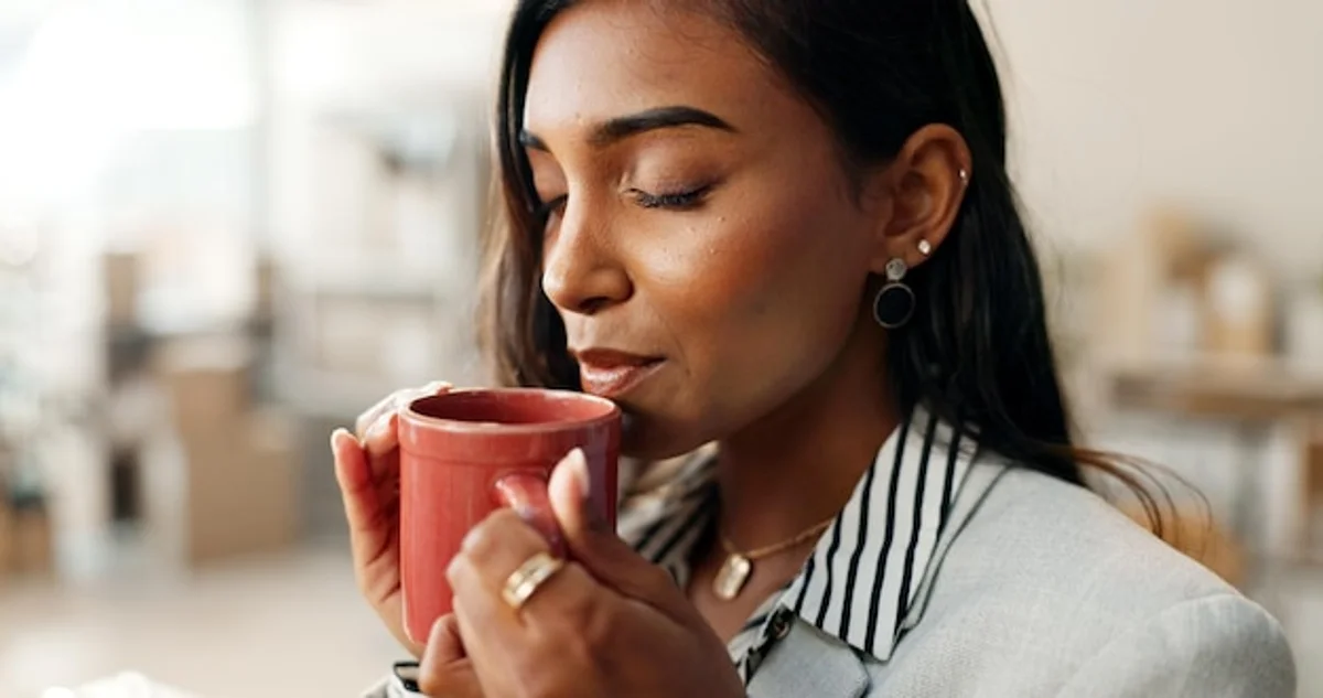 person taking a mindful break with a cup of coffee in workspace