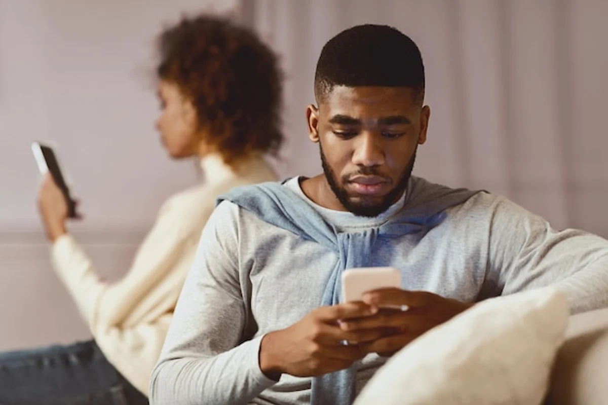 couple looking at phones ignoring each other