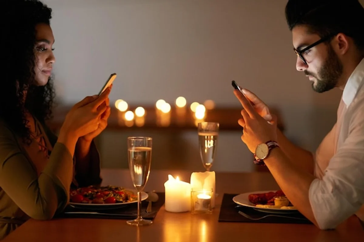 couple having dinner with phones on table
