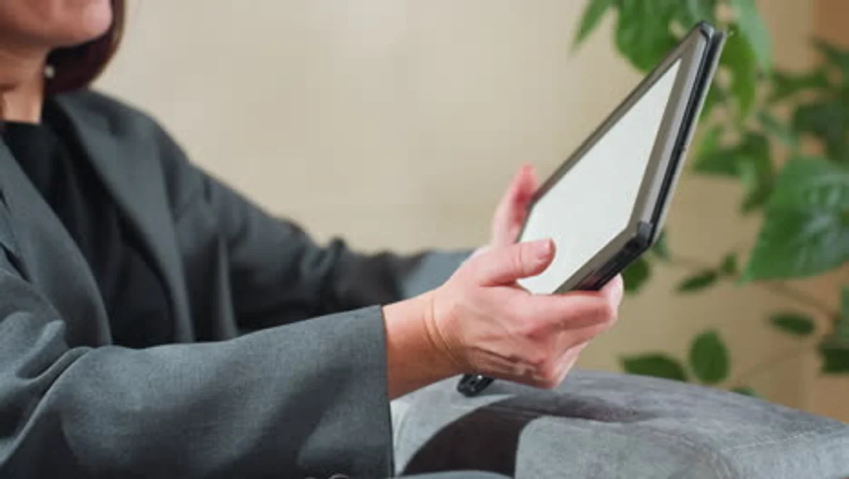 elderly person using tablet at home hands closeup bright light