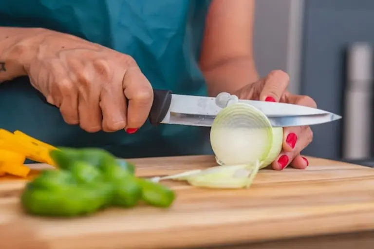 sharp kitchen knife chopping onion close up