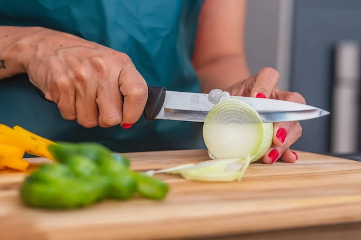 sharp kitchen knife chopping onion close up