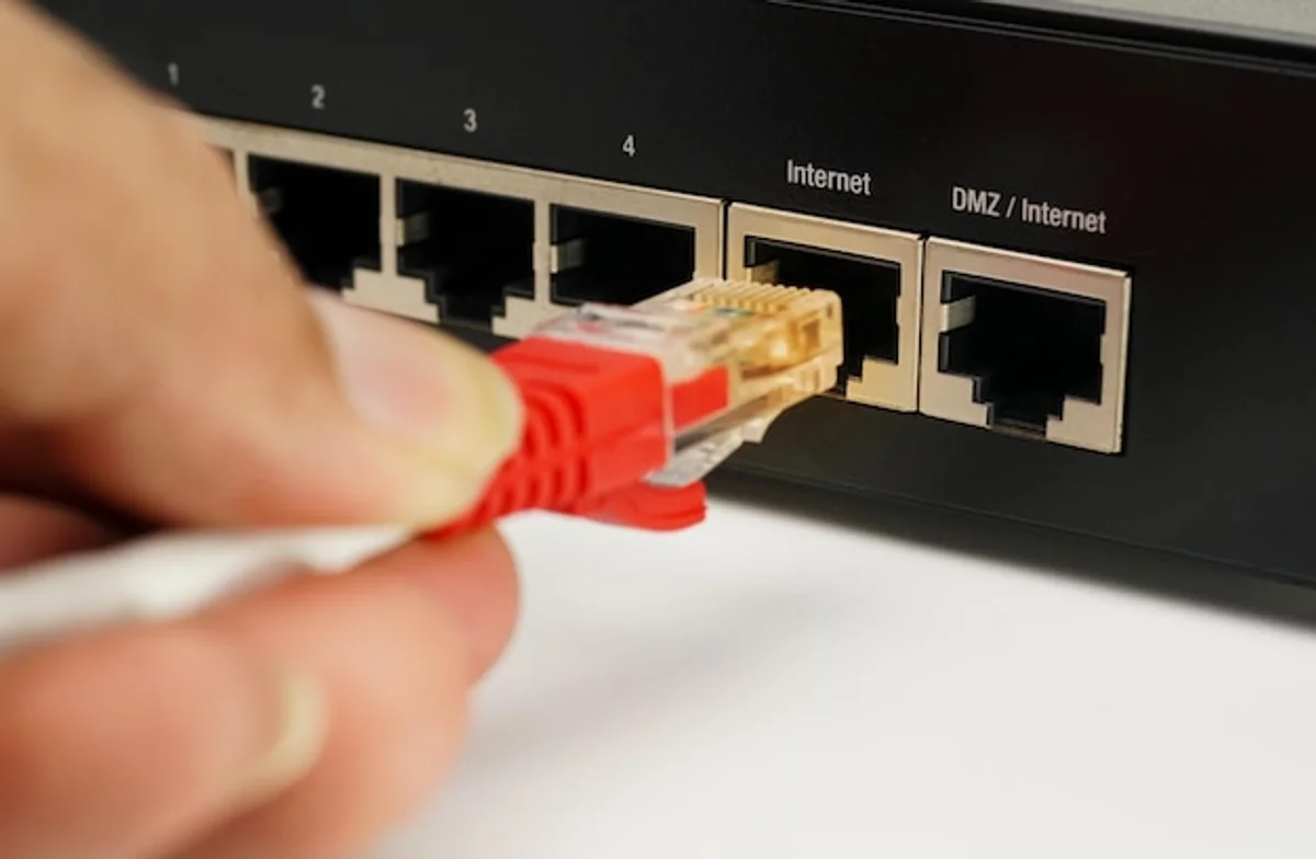 man pressing reset button on WiFi router close up