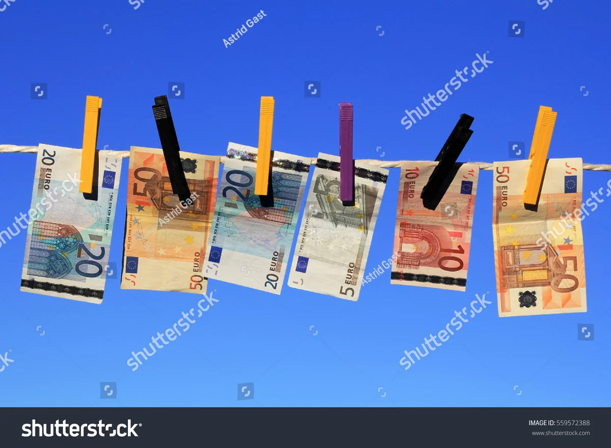 pile of euro notes next to second hand clothes flatlay germany