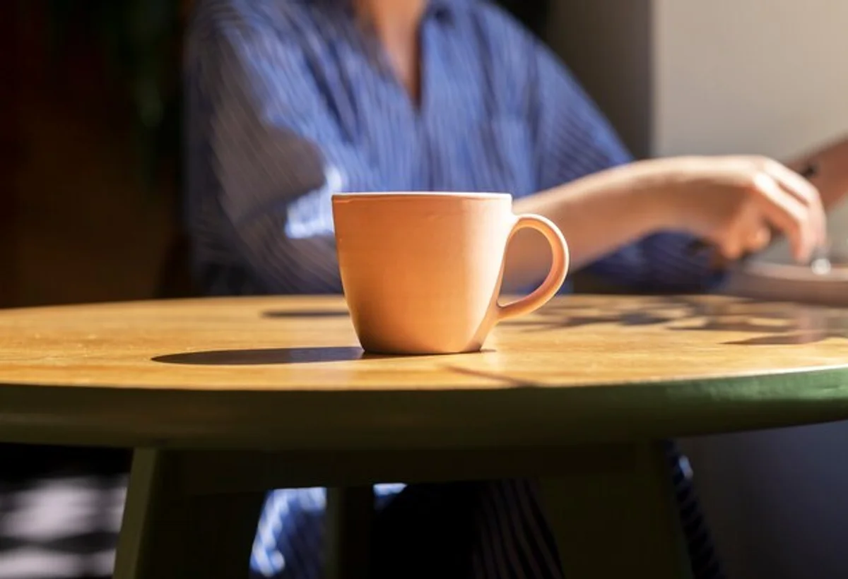 minimalist desk with sunlight and coffee cup