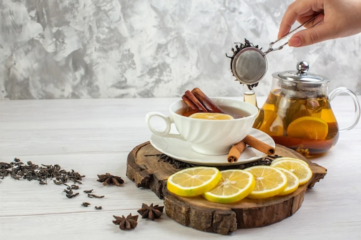 elderly hands holding walnuts, berries and a cup of green tea on wooden table