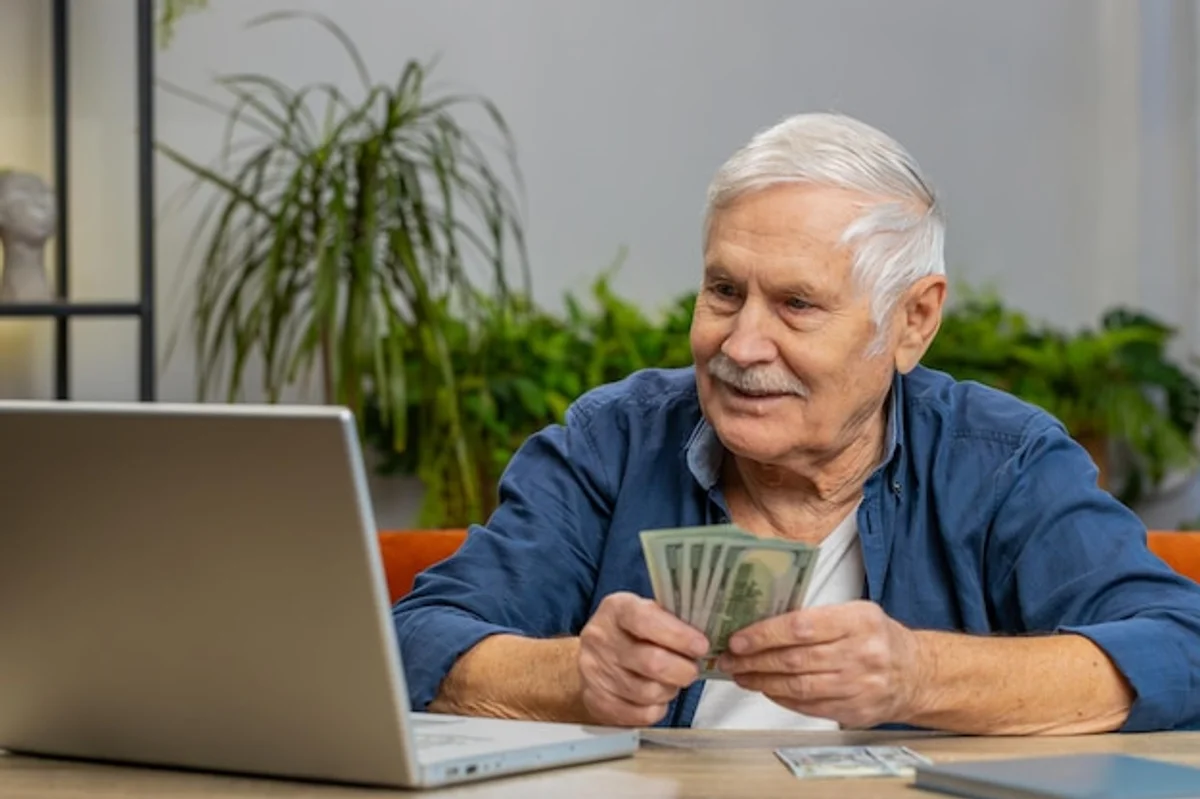 happy senior man calculating pension savings at home