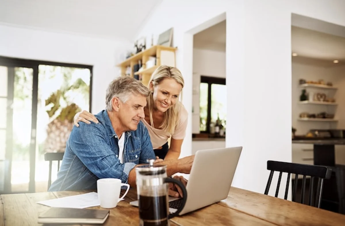 young couple planning retirement finances with laptop and coffee