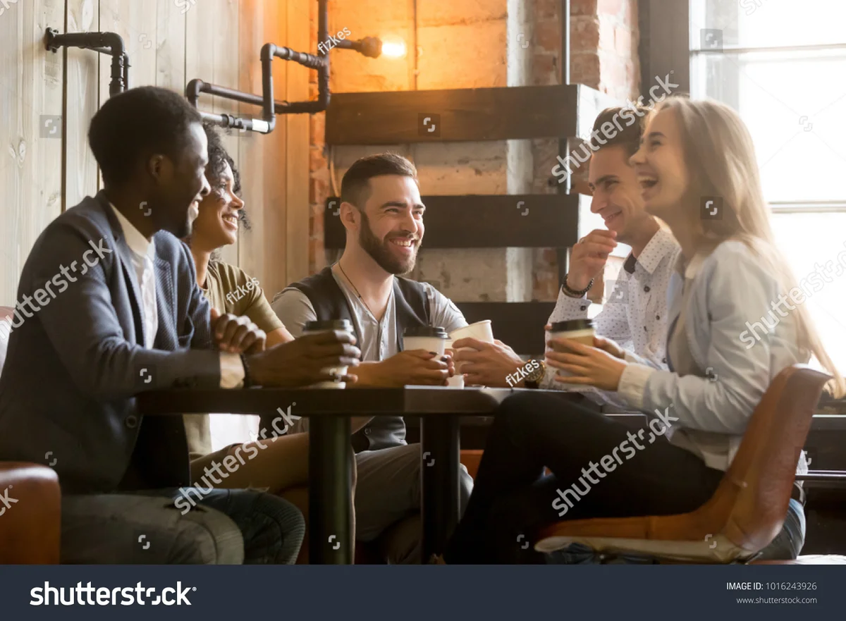 friends laughing at cafe table, urban germany, candid, diverse