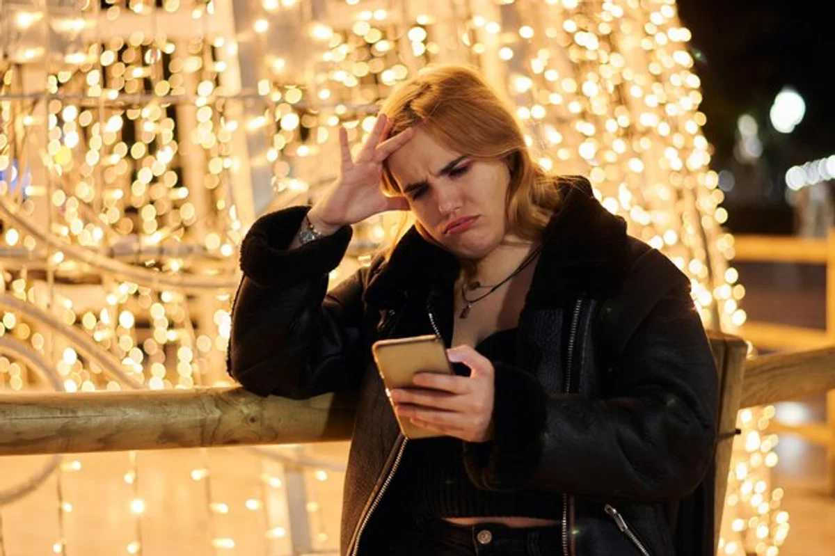 worried woman looking at smartphone at night 