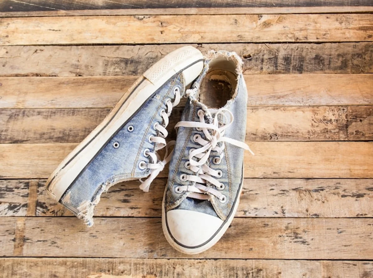 worn vintage sneakers on wooden floor