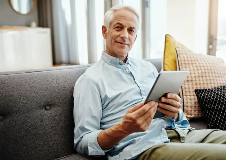 senior using tablet modern living room germany