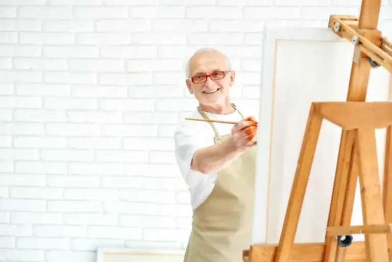 happy senior painting in bright art studio