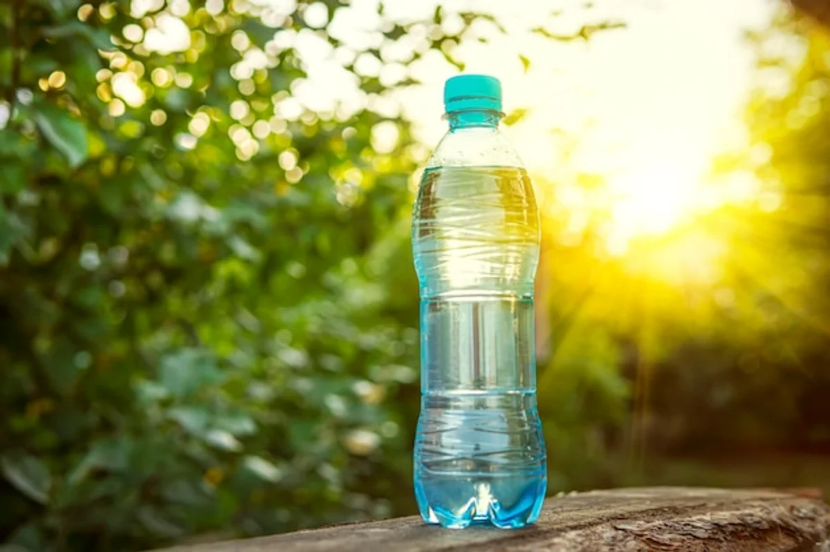 water bottle and glass on office desk with sun flare