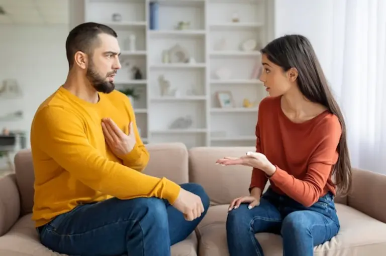 serious couple talking on a couch