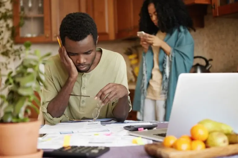frustrated man looking at bills at home