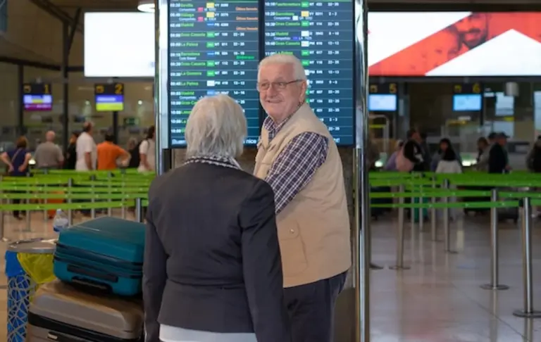senior couple travel safety airport suitcase