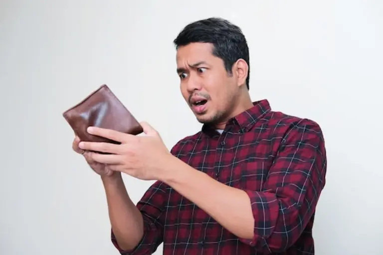 shocked person looking at empty wallet
