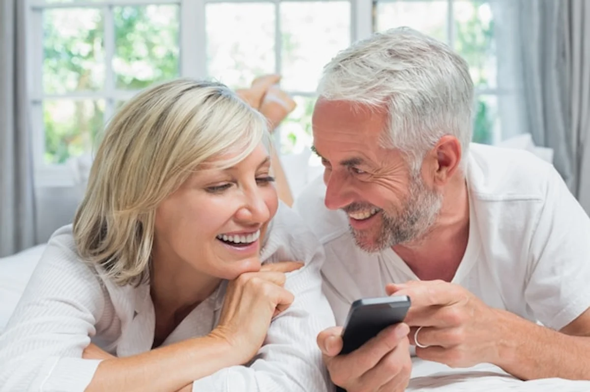 old couple reading phone messages together