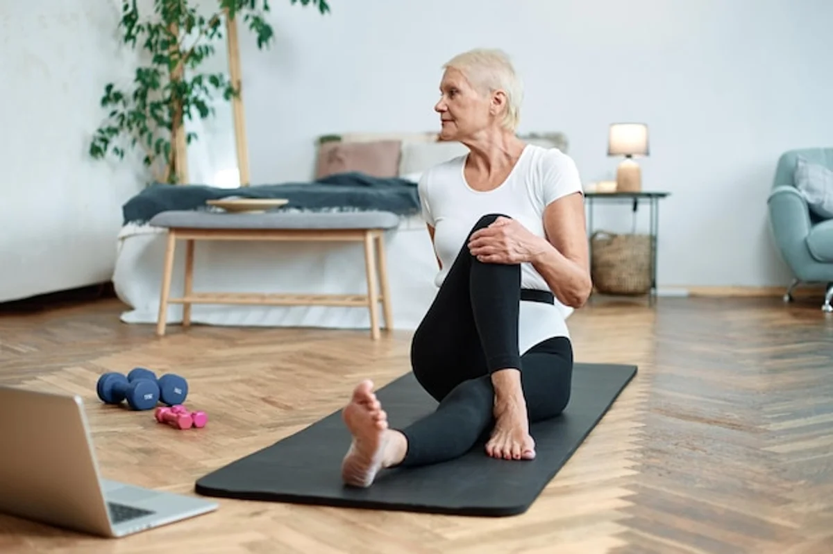 senior woman doing pilates mat exercise home living room