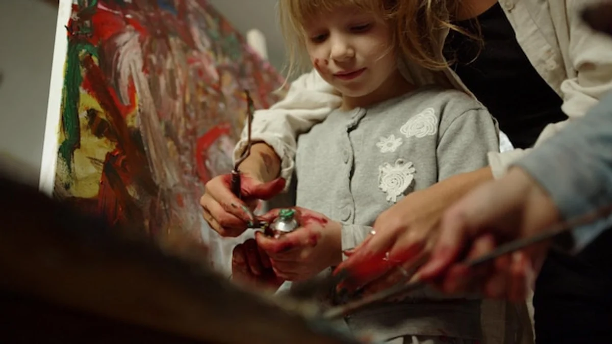 children painting with old colorful paint tubes at home