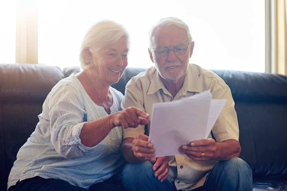 elderly couple budget planning at home sunny