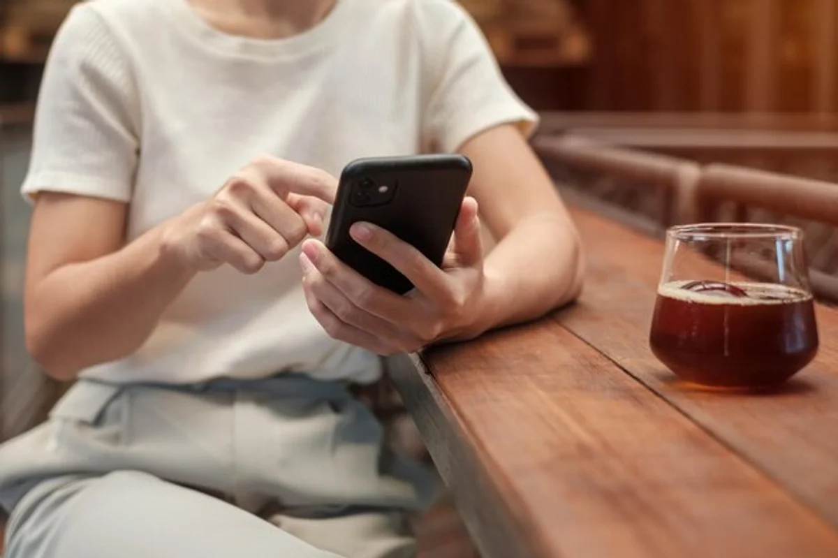 young woman using smartphone to pay at a Berlin cafe