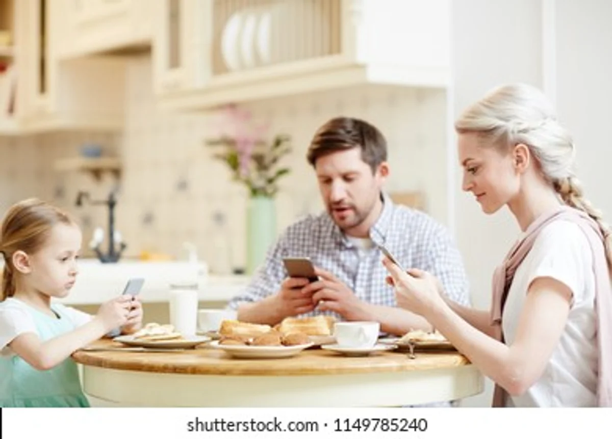 German family using tablet for budgeting together, cozy kitchen