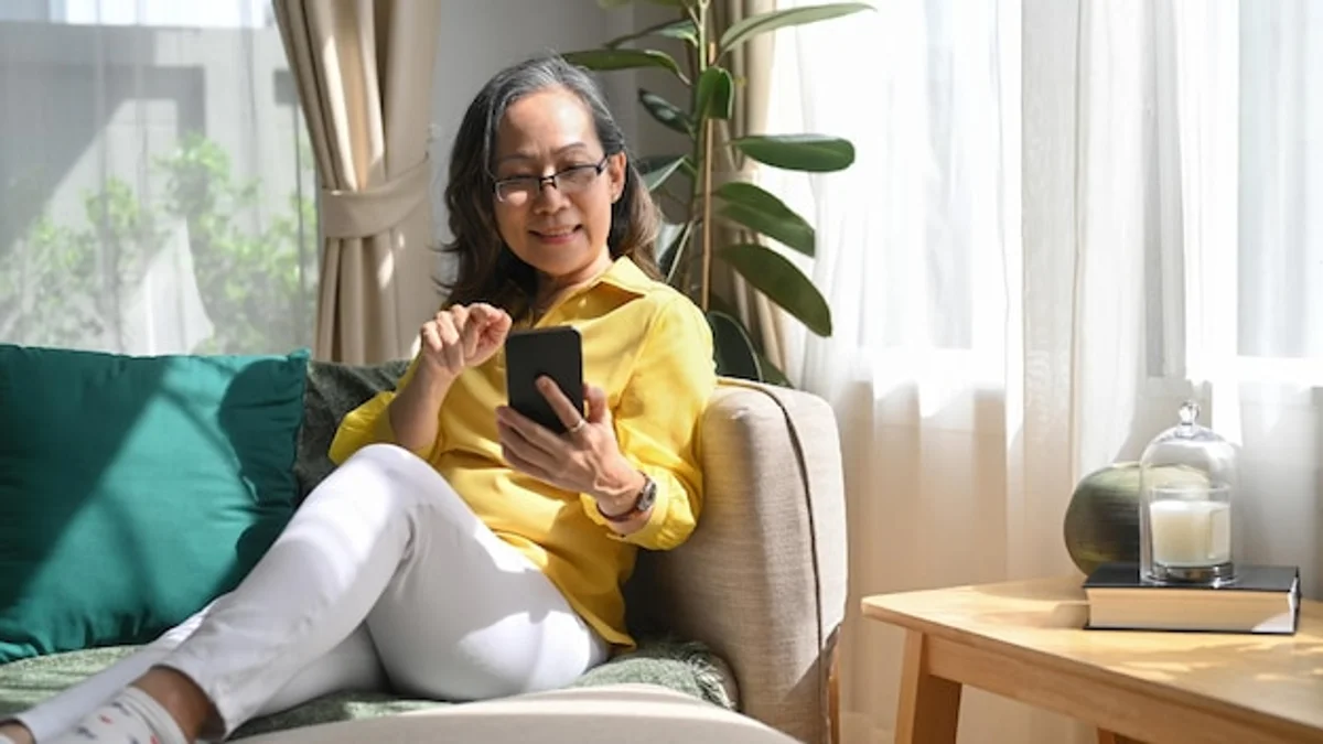 senior woman checking smartwatch smiling living room