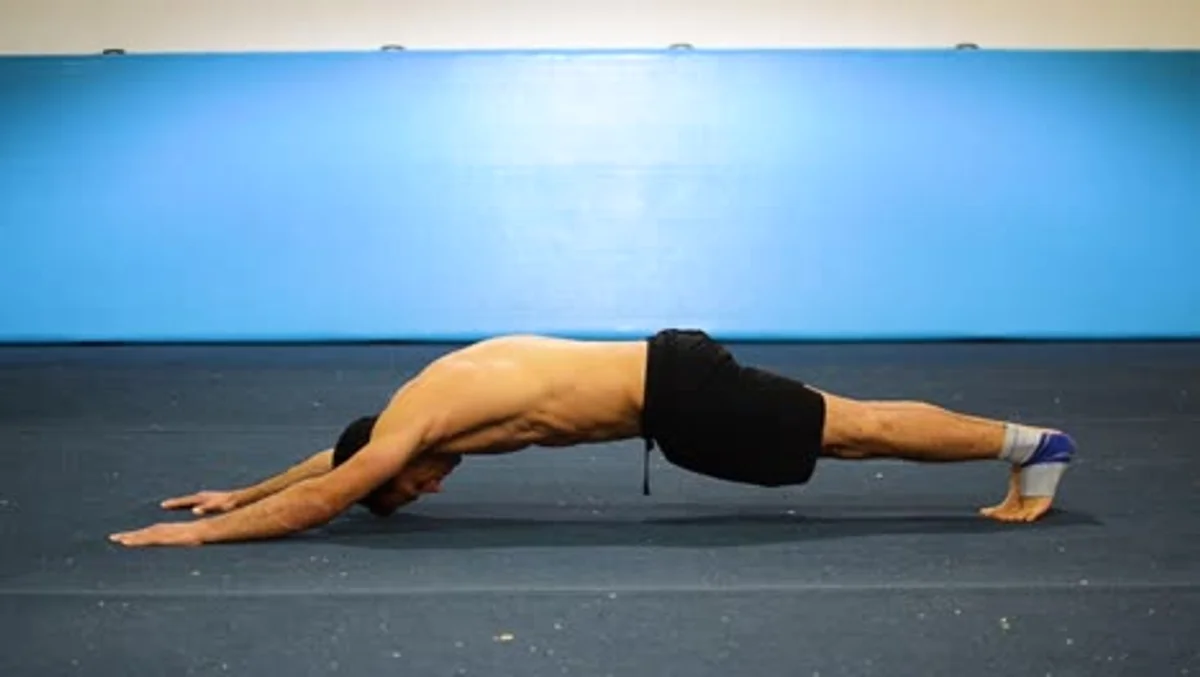 man stretching hamstrings floor morning sunlight