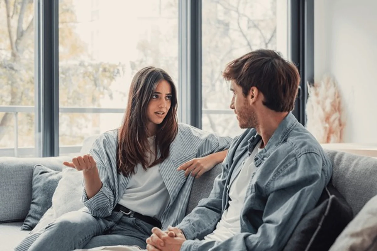 German couple talking honestly on the sofa, emotional conversation